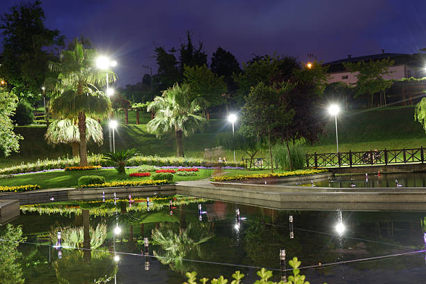 istock Evening Stroll by the Reflective Pond in a Lush Park 2240699449
