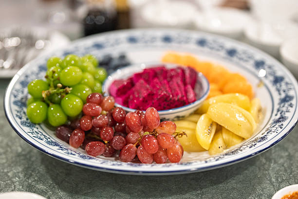 Assorted sliced fruits served on a plate at restaurant table