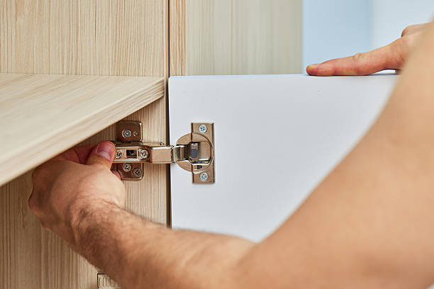 istock handyman assembling cabinet and screwing door hinge 2240701435