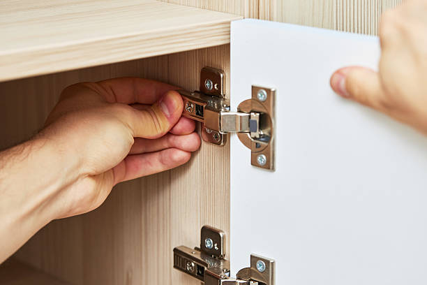 istock handyman assembling cabinet and screwing door hinge 2240701440