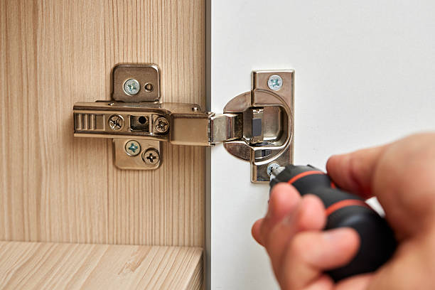 istock handyman assembling cabinet and screwing door hinge 2240701451