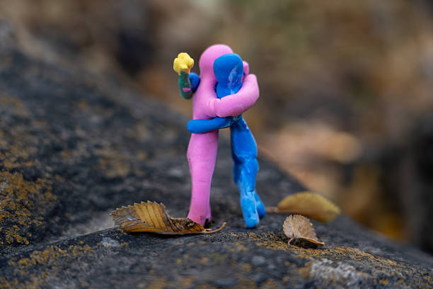 Romantic Plasticine Couple Hugging on Stone with Autumn Leaf