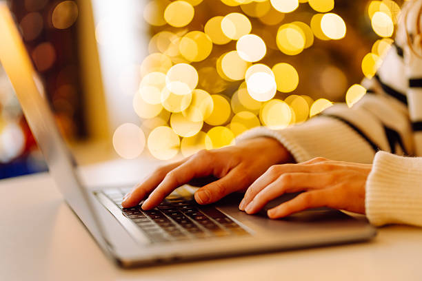 istock Close-up of hands typing on a laptop while sitting at a table in a cozy room. 2240703398