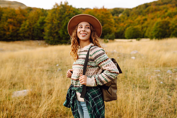 istock Hiker wearing hat and carrying backpack walks along hiking trail in mountains. 2240703488
