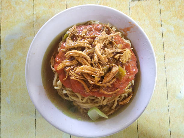 An overhead, close-up shot of a bowl of Mie Ayam (Indonesian Chicken Noodles)