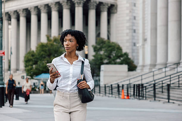 istock Modern urban professional woman using mobile device on the go 2240705036
