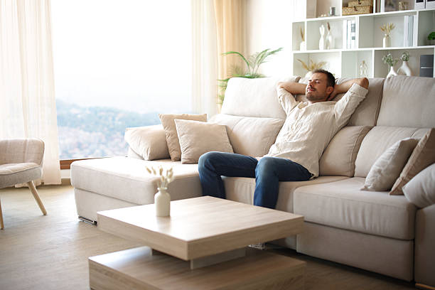 istock Man is relaxing sitting in a comfortable couch at home 2240708719