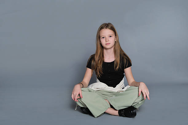 istock A girl poses casually while sitting on the ground with relaxed posture. The image reflects authentic youth moments often linked to emotional development and self-expression. 2240713850