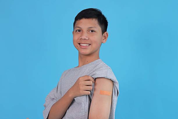 istock Asian Young Boy Showing His Arm with Bandage After Got Vaccinated or Child Immunization 2240714843