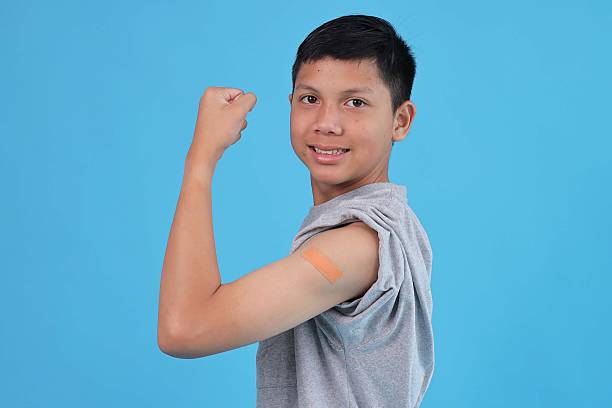 istock Healthy Asian Boy Flexing Arm After Vaccination Feeling Strong and Protected Against Blue Background 2240714963