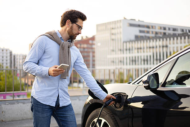 istock Man Charging Electric Vehicle 2240716008