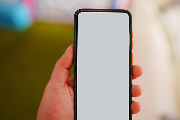 istock Smartphone held in hand with blank screen in a cozy indoor setting 2240717524