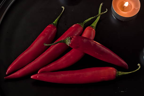 Three jalapeño peppers in low light