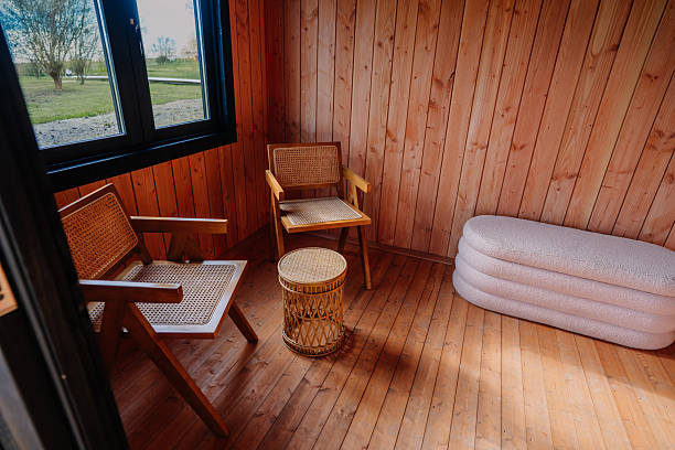 istock Minimal wooden interior with two rattan chairs, small wicker table, and soft white bench under a window, creating a cozy, natural reading or relaxation corner. 2240722846