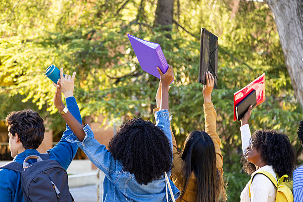 istock Diverse students raising hands celebrating school success 2240724042