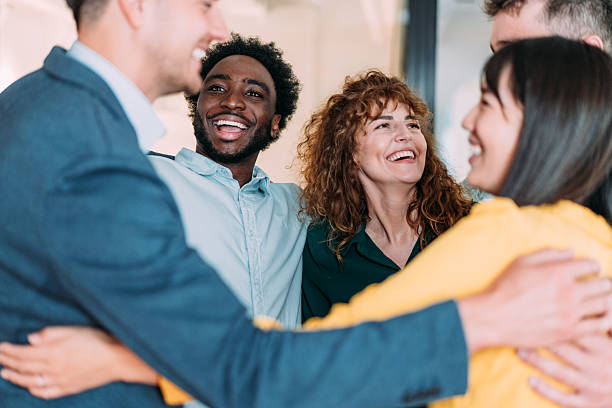 istock Excited coworkers embracing each other during a celebration in the office. 2240725030