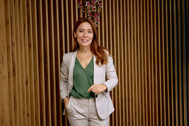 istock Businesswoman standing in office, smiling, looking at camera 2240725145
