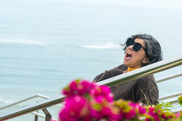 istock A woman is sitting on a railing overlooking the ocean 2240727557