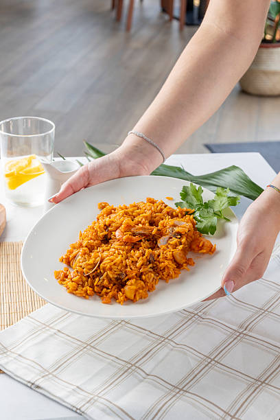 istock Hands serving traditional seafood paella rice dish 2240728520