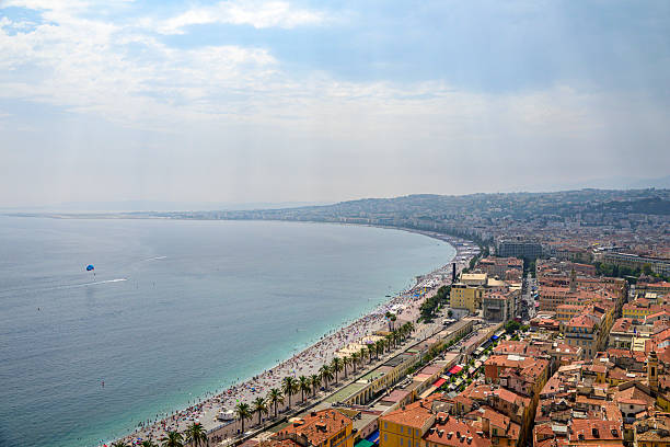 View on Nice over the Promenade des Anglais along the Mediterranean coast from Castle Hill (Colline du Château), France during a summer day. Located on the French Riviera, the southeastern coast of France on the Mediterranean Sea, at the foot of the French Alps, Nice is the second-largest French city on the Mediterranean coast and second-largest city in the Provence-Alpes-Côte d'Azur region