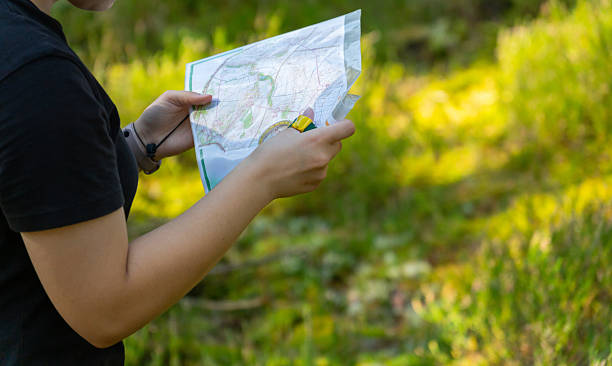 istock Orienteering athlete running through a summer forest with a map and compass. 2240730155