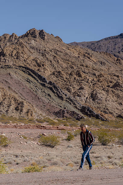 istock Man walking in arid mountain landscape on a sunny day 2240730192
