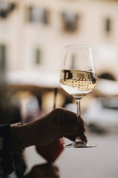 istock Hand Holding Wine Glass with City Reflection 2240732362