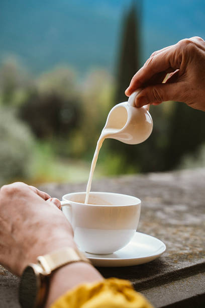 Pouring Milk into Coffee Cup Outdoors