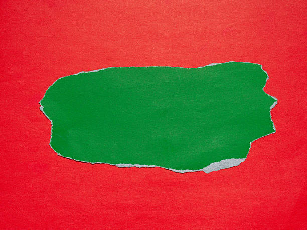 istock Piece of torn green paper on a red background. 2240733962