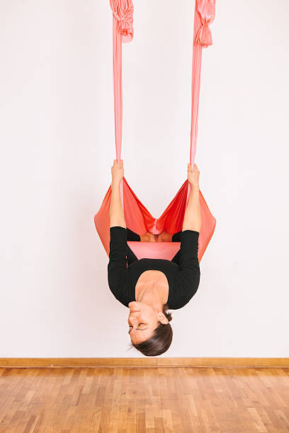 istock Woman inverted in aerial silk hammock holding straps — AERIAL_SILK_TUTORIAL_22_of_100 2240735030