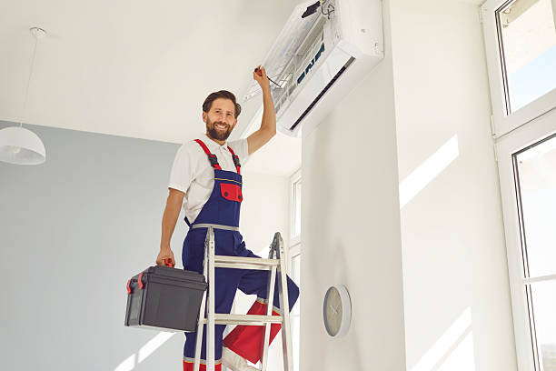 istock Smiling Technician Repairs Conditioner Unit on Ladder 2240738039