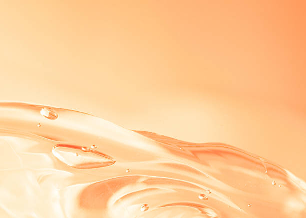 istock Macro background with glossy liquid and smooth curves. Rich peach-orange color. Abstract wave of transparent gel with air bubbles. Light warm gradient. Copy space 2240739223