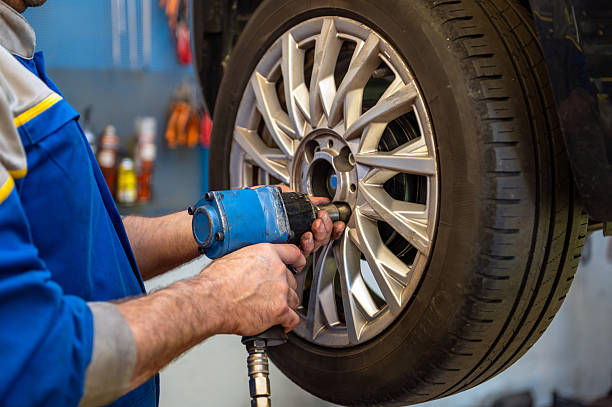istock Mechanic using impact wrench changing car wheel 2240742989