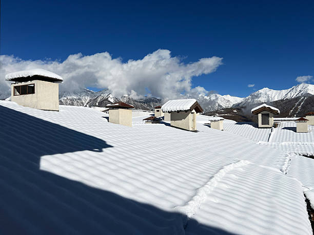 Snow-covered rooftops with distinct chimneys create a serene winter landscape under a bright blue sky, beauty of nature and architecture , season