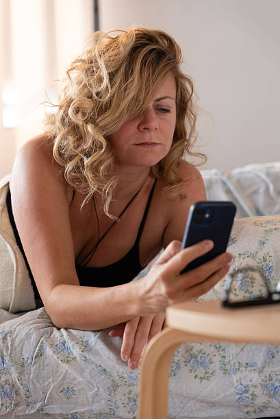 istock Woman lying in bed using smartphone in the morning 2240744248