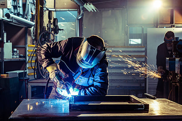 istock Industrial worker welding metal frame in factory workshop 2240744366