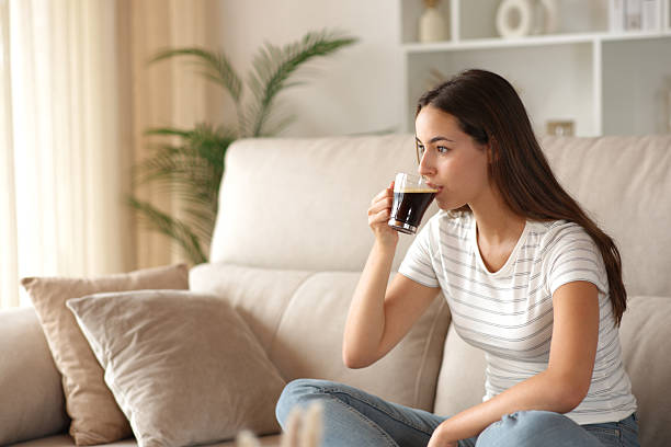 istock Woman at home drinking coffee on a couch 2240744429