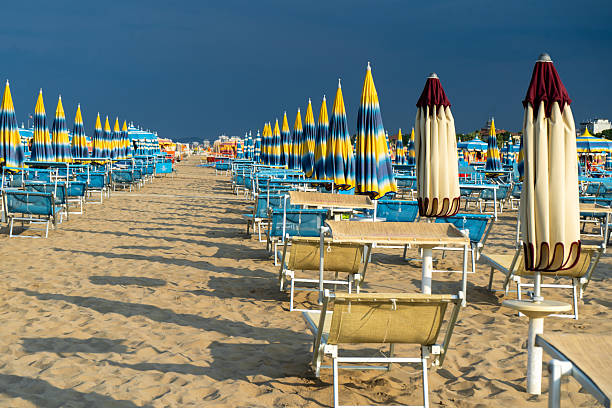 istock Sun loungers on sandy beach with Umbrellas. Empty seaside resort. Italy. 2240744643