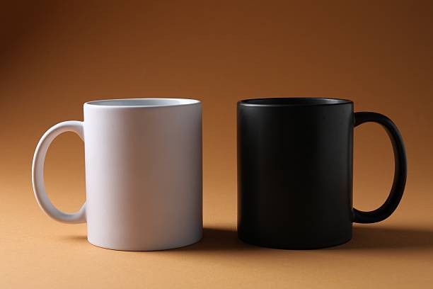 istock Promotion. White and black mugs on brown background 2240746817