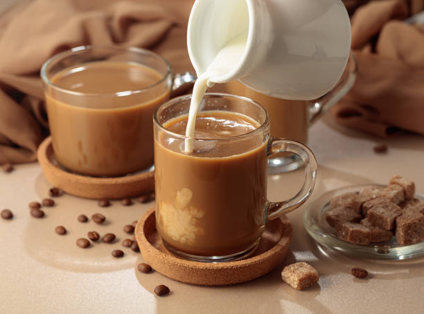 istock Pouring cream in black coffee. 2240750040