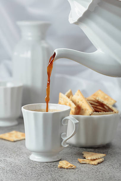 istock Black coffee in white porcelain cup and crunchy square crackers. 2240750058