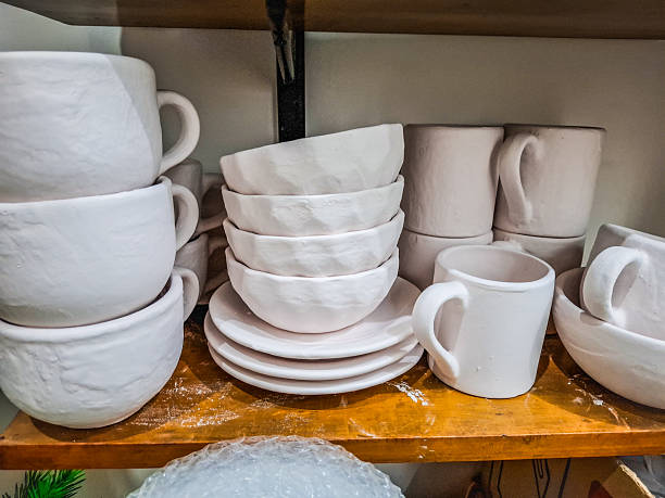 Shelf with cups, bowls and plates in pottery warehouse