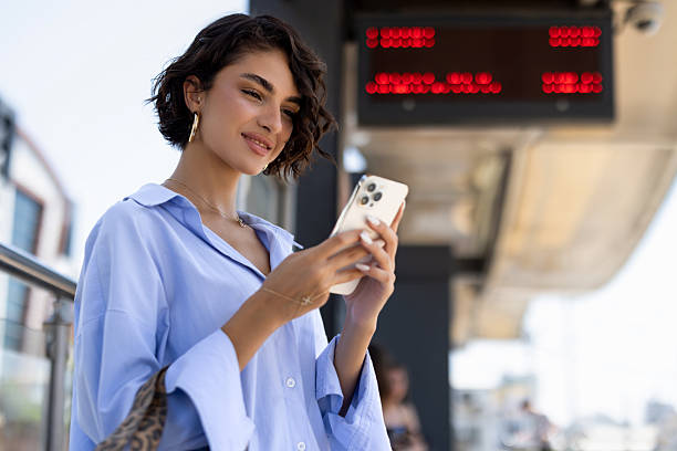 Woman waiting at station and using phone