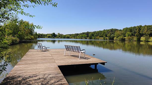 istock Serene Summer View from a Wooden Dock with Empty Benches 2240752302