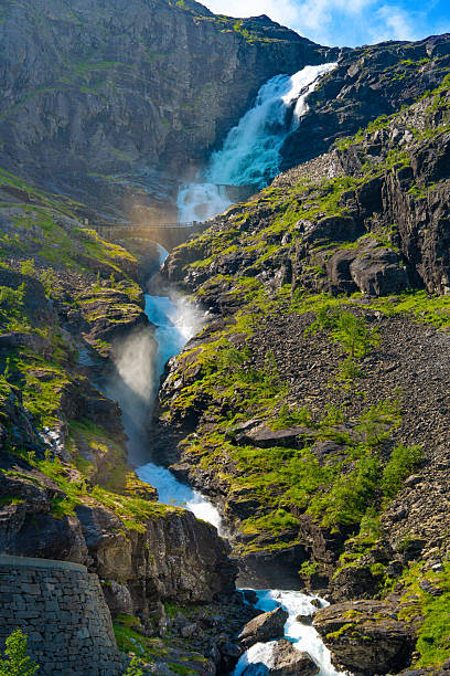 Waterfall with mist view from below Trollstigen Norway summer mountain road trip travel adventure