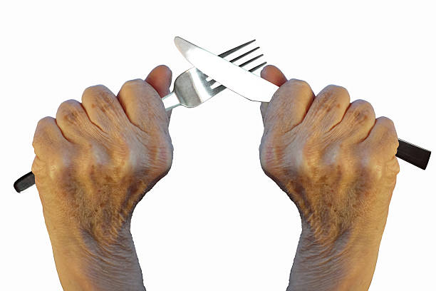 Hands holding a cutlery set, a fork and a table knife