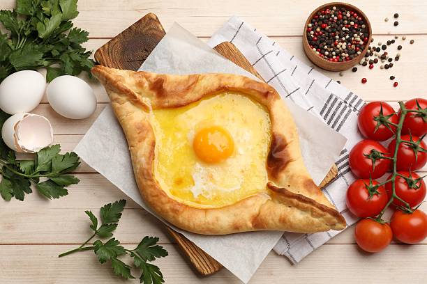 istock Tasty khachapuri with cheese and egg served on wooden table, flat lay 2240760693