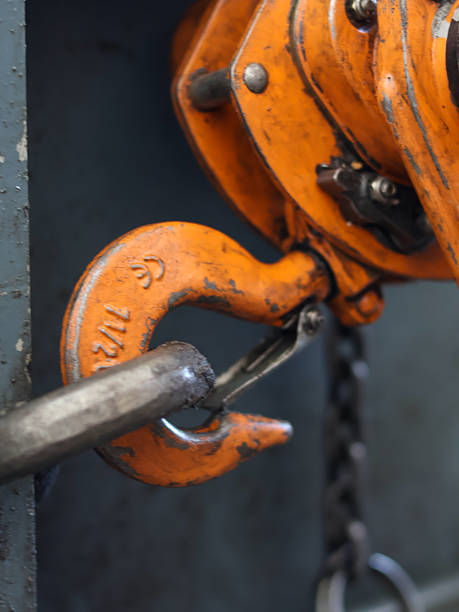 istock Close-up of a sturdy, orange chain hoist hook 2240764439