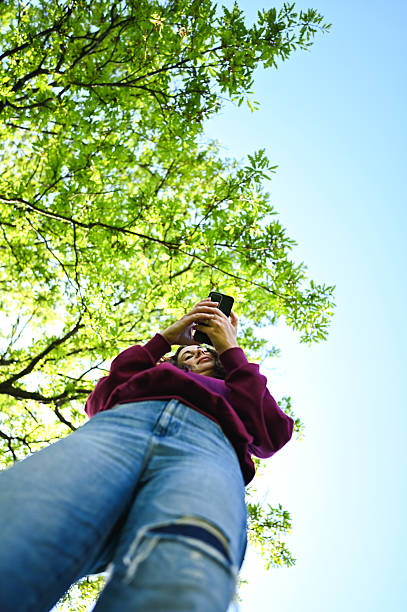 istock Young woman connecting with smart phone outdoors in nature 2240766469