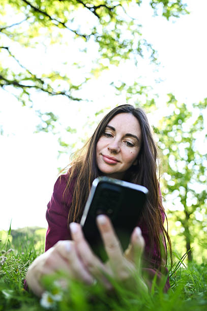 istock Woman relaxing outdoors in nature checking smartphone 2240766575